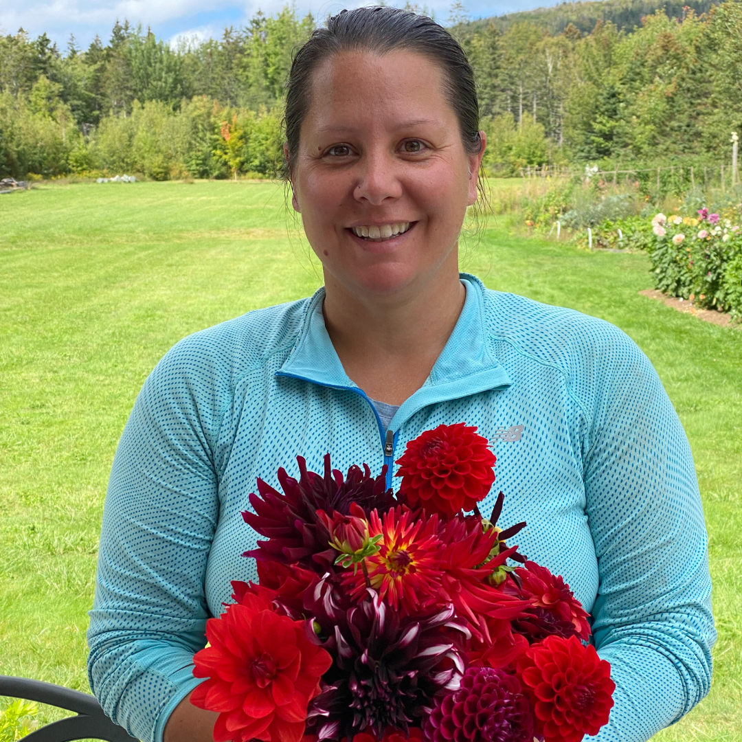 Kari Rouse with a red bouquet of dahlias